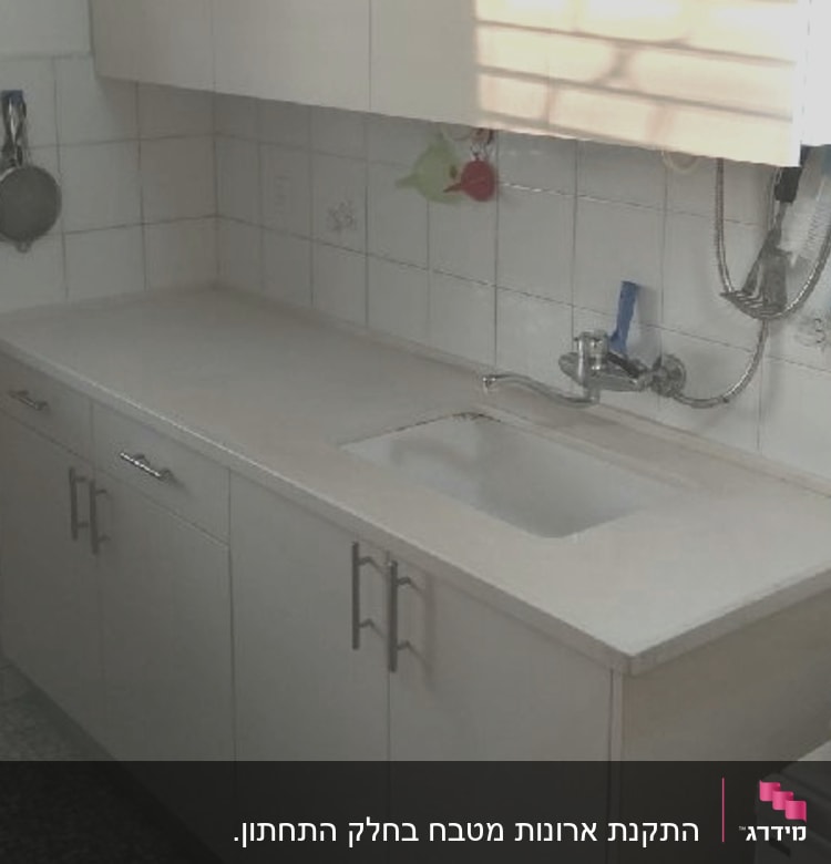 מטבח עם ארונות, כיור וברז מותקן